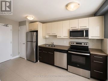 St. Catharines (Downtown) multi-family for rent - A kitchen with white cabinets and stainless steel appliances.