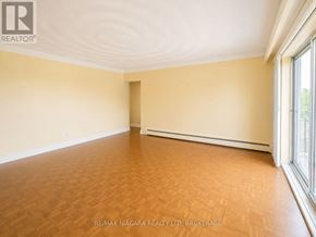 St. Catharines (Downtown) multi-family for rent - A room with wooden flooring and a window on the right side.