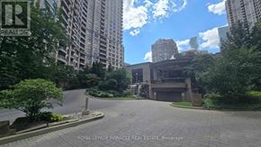 Mississauga (City Centre) condo for rent - A paved courtyard is surrounded by trees and buildings.