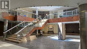 Mississauga (City Centre) condo for rent - A staircase with a glass railing and a wooden handrail.