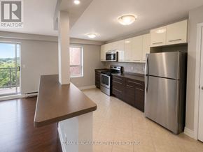 St. Catharines (Downtown) multi-family for rent - A kitchen with a refrigerator, microwave, oven, and sink.