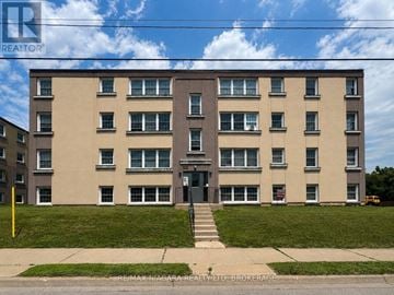 St. Catharines (E. Chester) multi-family for rent - A building with a green lawn in front of it.