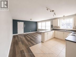 St. Catharines (E. Chester) multi-family for rent - A spacious kitchen with dark grey walls and wooden flooring.