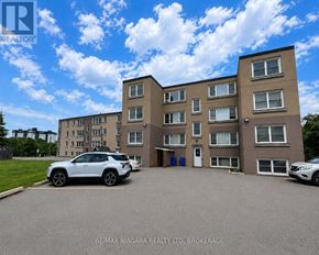 St. Catharines (E. Chester) multi-family for rent - A white car is parked in front of a building with a sign that reads "RE/MAX NIAGARA REALTY LTD. BROKERAGE.".