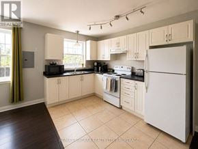 St. Catharines (E. Chester) multi-family for rent - A kitchen with white appliances and wooden cabinets.