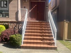 Vancouver apartment for rent - A set of stairs with a metal railing leading to a brown door.
