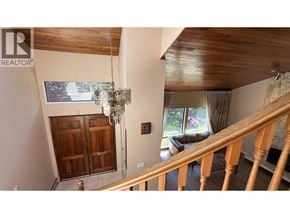 Vancouver apartment for rent - A wooden staircase leads to a living room with a couch and a chandelier.