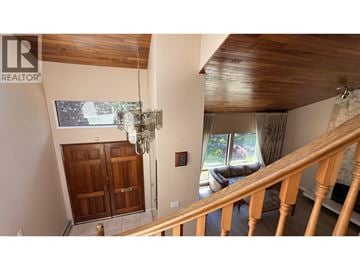 Vancouver apartment for rent - A wooden staircase leads to a living room with a couch and a chandelier.