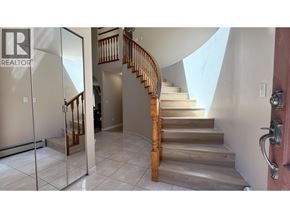 Vancouver apartment for rent - A staircase with a wooden handrail and tiled flooring.