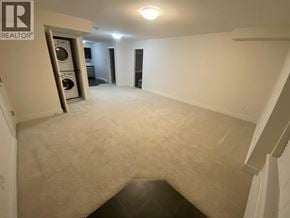 Coquitlam apartment for rent - A spacious room with a washer and dryer in the corner.