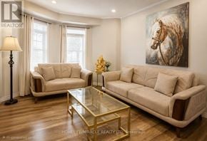 Brampton (Fletcher's Meadow) townhouse for rent - A living room with a beige couch, a glass coffee table, and a painting of a horse on the wall.
