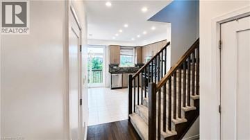 Ancaster townhouse for rent - A hallway with a staircase leading to a kitchen area.