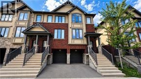Ancaster townhouse for rent - A large, multi-story house with a red brick facade and a stone entrance.