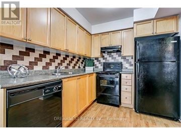 Mississauga (Churchill Meadows) townhouse for rent - A kitchen with wooden cabinets and black appliances.