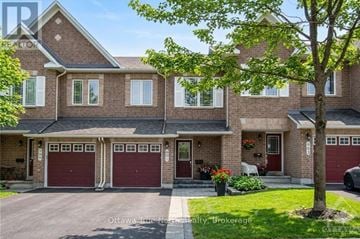 Ottawa townhouse for rent - A large brick house with a tree in front.