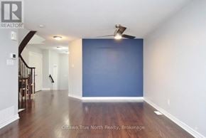 Ottawa townhouse for rent - A spacious room with a staircase on the left and a ceiling fan above.