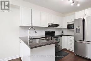 Ottawa townhouse for rent - A kitchen with white cabinets and stainless steel appliances.