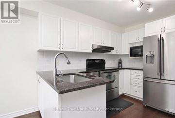 Ottawa townhouse for rent - A kitchen with white cabinets and stainless steel appliances.