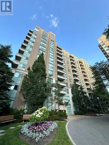 Toronto (Newtonbrook East) condo for rent - A tall residential building with a well-maintained garden in front.