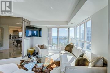 Toronto (Mimico) condo for rent - A modern living room with a glass table and white couches.