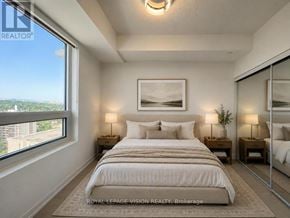 Toronto (Humber Heights) condo for rent - A bedroom with a large bed and a view of the city.