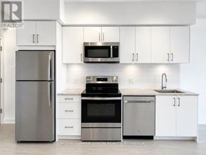 Toronto (Humber Heights) condo for rent - A modern kitchen with white cabinets and stainless steel appliances.