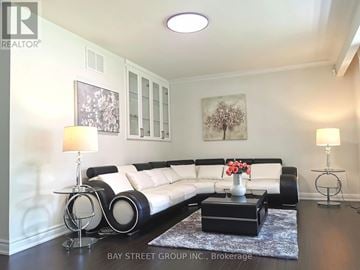 Toronto (Bayview Village) apartment for rent - A living room with a white couch, a coffee table with flowers, and two lamps.