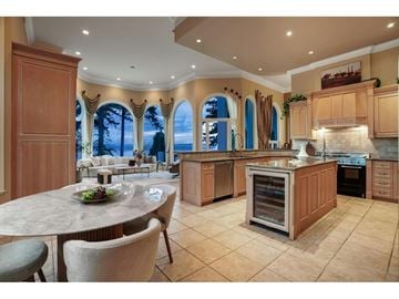 Surrey apartment for rent - A kitchen with a table and chairs in front of a window with a view of the ocean.