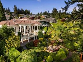 Surrey apartment for rent - A large house with a red roof and a patio surrounded by a lush green garden.