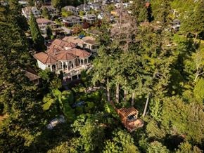 Surrey apartment for rent - A large house with a red roof is surrounded by trees.