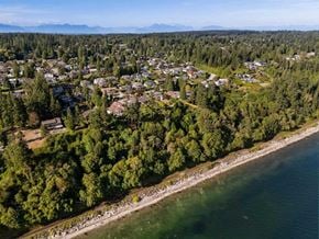 Surrey apartment for rent - A coastal town with houses and trees by the shore.
