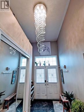 Vaughan (Vellore Village) apartment for rent - A chandelier hangs from the ceiling in a room with a wooden door and a bench.