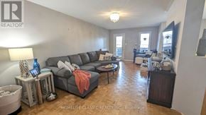 Vaughan (Vellore Village) apartment for rent - A living room with a grey couch and a wooden floor.