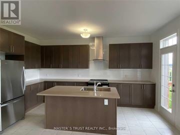 East Gwillimbury (Holland Landing) apartment for rent - A kitchen with brown cabinets and a stainless steel refrigerator.