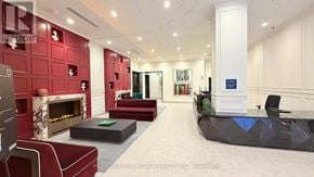Toronto (Moss Park) condo for rent - A living room with a fireplace and a long black couch.