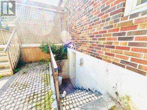 Toronto (Willowdale East) apartment for rent - A brick wall with a white door and a wooden staircase.