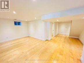 Toronto (Willowdale East) apartment for rent - A spacious room with wooden flooring and white walls.