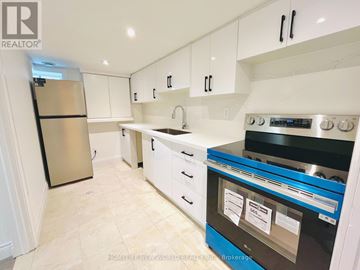 Toronto (Willowdale East) apartment for rent - A kitchen with white cabinets and a black stove top oven.