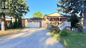 Richmond Hill (Crosby) apartment for rent - A house with a driveway and a garage is surrounded by trees and has a white fence.