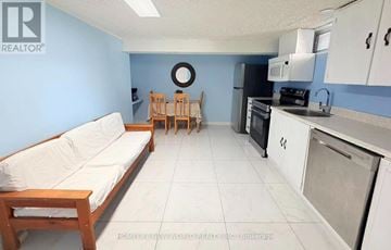 Richmond Hill (Crosby) apartment for rent - A kitchen and living room with a white couch and wooden chairs.