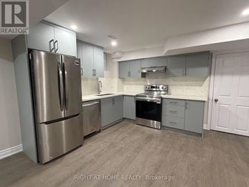 Halton Hills (Georgetown) apartment for rent - A kitchen with a refrigerator, stove, and cabinets.