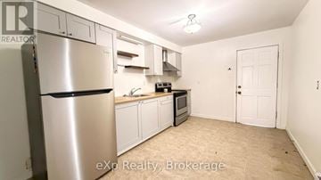 Belleville (Belleville Ward) fourplex for rent - A kitchen with a stainless steel refrigerator and white cabinets.