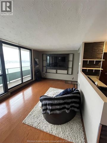 Windsor condo for rent - A living room with a chair and a television.