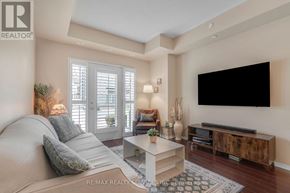 Mississauga (Churchill Meadows) condo for rent - A living room with a grey couch, a white coffee table, and a flat screen TV mounted on the wall.