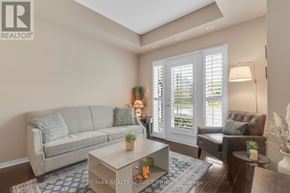 Mississauga (Churchill Meadows) condo for rent - A living room with a grey couch, a coffee table, and a brown chair.