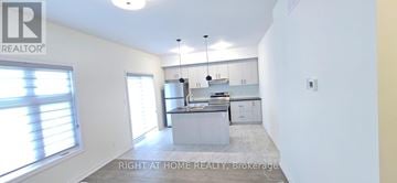 Niagara Falls (Hospital) house for rent - A well-lit kitchen with white cabinets and a large island.