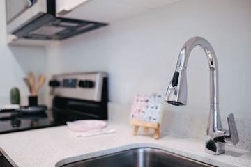 Seattle apartment for rent - A kitchen sink with a modern faucet and a small wooden calendar on the counter.