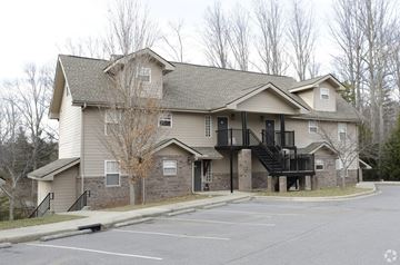 Candler apartment for rent - A large two-story building with a parking lot in front.
