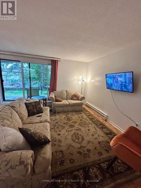 Toronto (Hillcrest Village) townhouse for rent - A living room with a couch, a chair, a rug, and a flat screen TV.