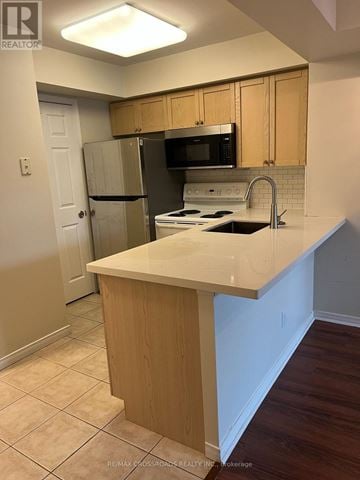Toronto (Willowdale East) condo for rent - A kitchen with a white counter top and wooden cabinets.